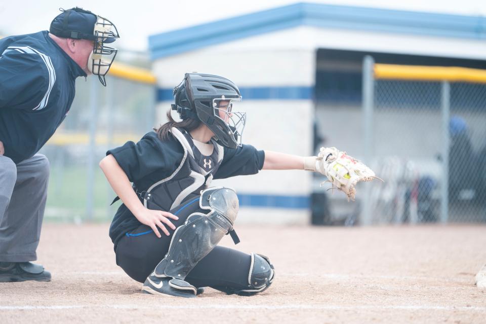 Harper Creek senior Breegan Woodworth catches a pitch during a game against Jackson Northwest at Harper Creek High School on Tuesday, April 23, 2024.