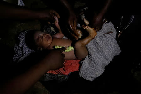 A neighbour and a relative take care of newborn Rebeca at her house in Boucan Ferdinand, Haiti, October 8, 2018. REUTERS/Andres Martinez Casares