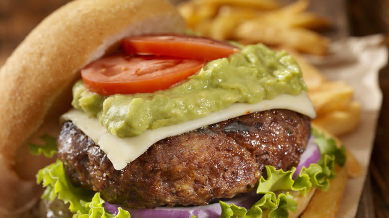 Guacamole on burger with tomato, lettuce