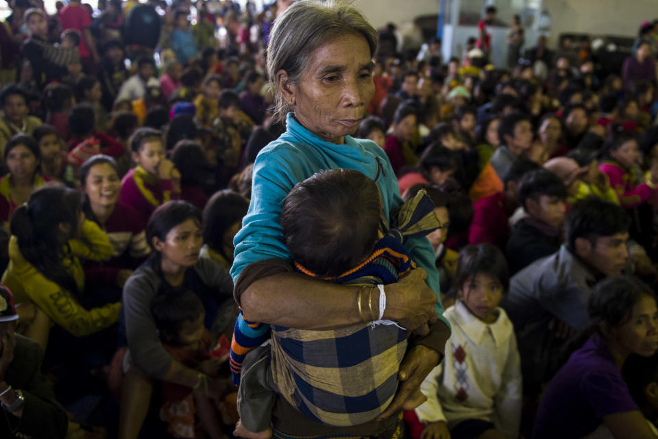 <p>An elderly woman carries a child while other residents displaced by massive flood waters from the collapsed dam seek shelter in Paksong town in Champasak province on July 25, 2018. (Photo: Ye Aung Thu/AFP/Getty Images) </p>