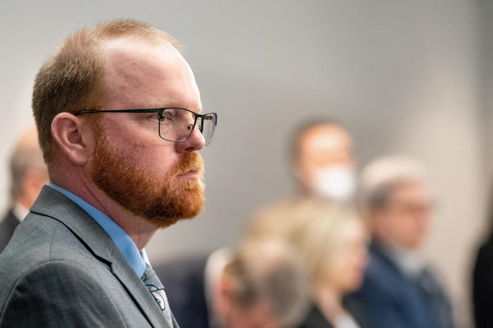 Defendant Travis McMichael stands in the courtroom.