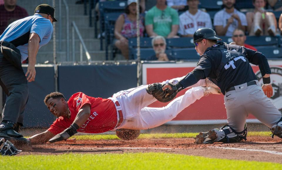 Worcester's Jeter Downs dives for home, but is tagged out by RailRiders catcher Max McDowell.