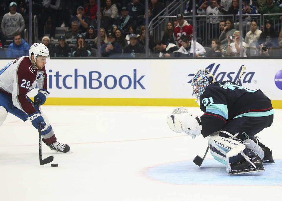 Colorado Avalanche center Nathan MacKinnon (29) prepares to shoot on Seattle Kraken goaltender Philipp Grubauer (31) for the only goal of the shootout in an NHL hockey game Saturday, Jan. 21, 2023, in Seattle. The Avalanche won 2-1. (AP Photo/Lindsey Wasson)