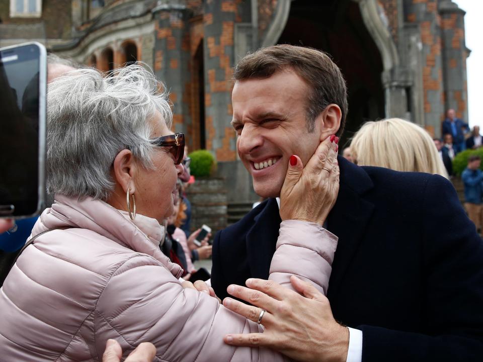 French President Emmanuel Macron smiles to a supporter after voting in the European parliamentary elections in Le Touquet, northern France, Sunday May 26, 2019. France is looking at an epic battle between pro-EU centrist President Emmanuel Macron and anti-immigration, far-right flagbearer Marine Le Pen in the European Parliament vote, a duel over Europe's basic values. (AP Photo/Kamil Zihnioglu)