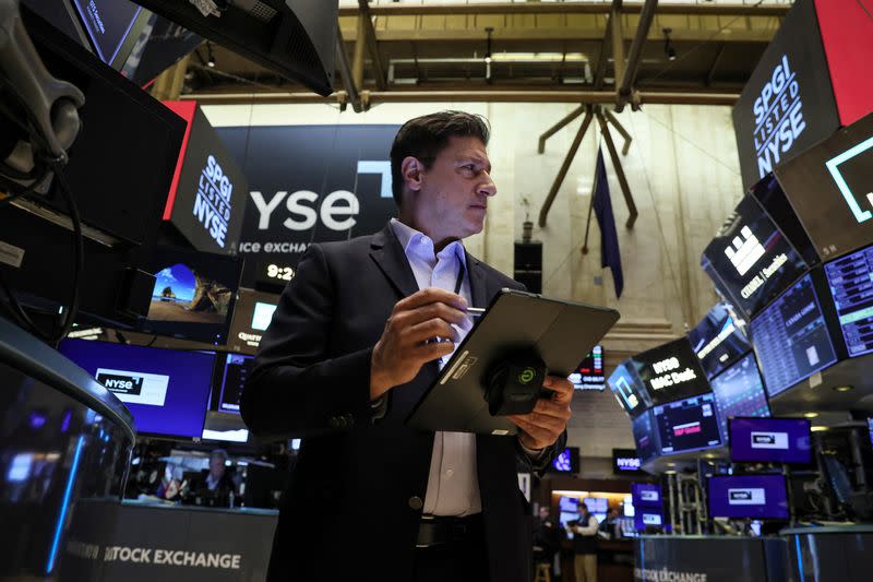 FILE PHOTO: Traders work on the floor of the NYSE in New York