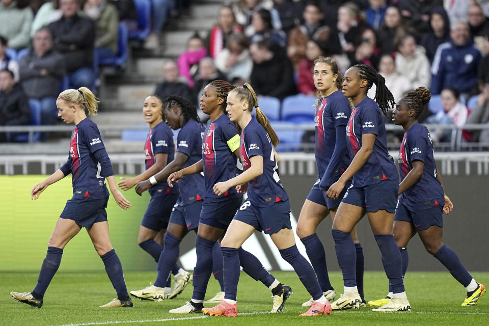 PSG players walk back to their side of the pitch Marie-Antoinette Katoto, 2nd right, scored their second goal during the women's Champions League semifinals, first leg, soccer match between Olympique Lyonnais and Paris Saint-Germain at Parc Olympique Lyonnais, in Lyon, France, Saturday, April 20, 2024. (AP Photo/Laurent Cipriani)