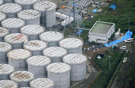 An aerial view shows workers wearing protective suits and masks working atop contaminated water storage tanks at Tokyo Electric Power Co. (TEPCO)'s tsunami-crippled Fukushima Daiichi nuclear power plant in Fukushima, in this photo taken by Kyodo August 20, 2013. REUTERS/Kyodo/File