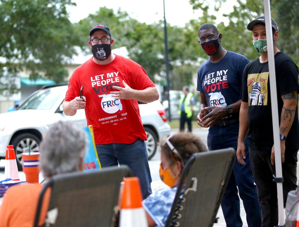 Deputy chair of the Florida Rights Restoration Coalition Neil Volz, left, and Chasman Barnes, center, and Jonathan Nostades talk to a few poll workers about the Amendment 4 tour involving the restoration of voting rights for felons in Florida, outside the Supervisor of Elections Office, in Gainesville on Oct. 27, 2020.