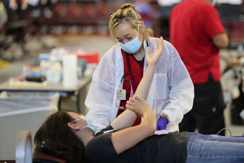 A woman gives blood at a Red Cross blood drive, as the global outbreak of the coronavirus disease (COVID-19) continues, in Los Angeles