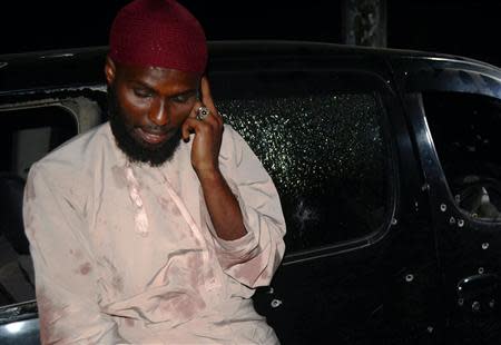 Salim Aboud talks on his phone after he survived the shooting at their vehicle in which Sheikh Ibrahim Ismael and three others were killed near Kenya's coastal city of Mombasa, October 4, 2013. REUTERS/Charles Makunda