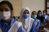 Students wearing face masks to prevent the spread of coronavirus, attend a class at a school, in Islamabad, Pakistan, Tuesday, Sept. 15, 2020. Pakistani officials welcomed millions of children back to school following educational institutions reopened on Tuesday in the country amid a steady decline in coronavirus deaths and infections. (AP Photo/Anjum Naveed)