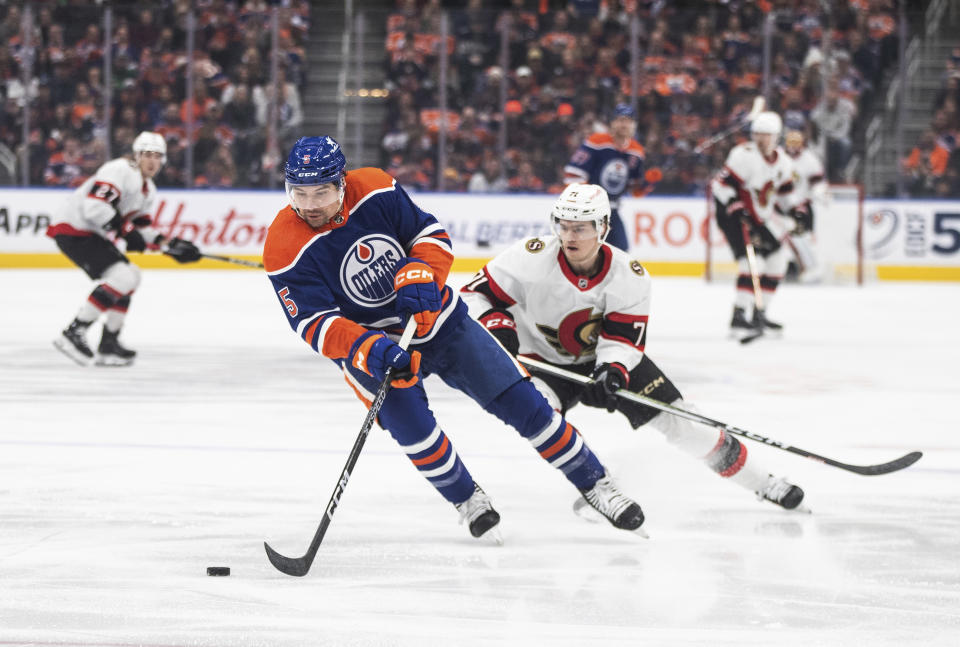 Ottawa Senators' Ridly Greig (71) chases Edmonton Oilers' Cody Ceci (5) during the first period of an NHL hockey game Saturday, Jan. 6, 2024, in Edmonton, Alberta. (Jason Franson/The Canadian Press via AP)