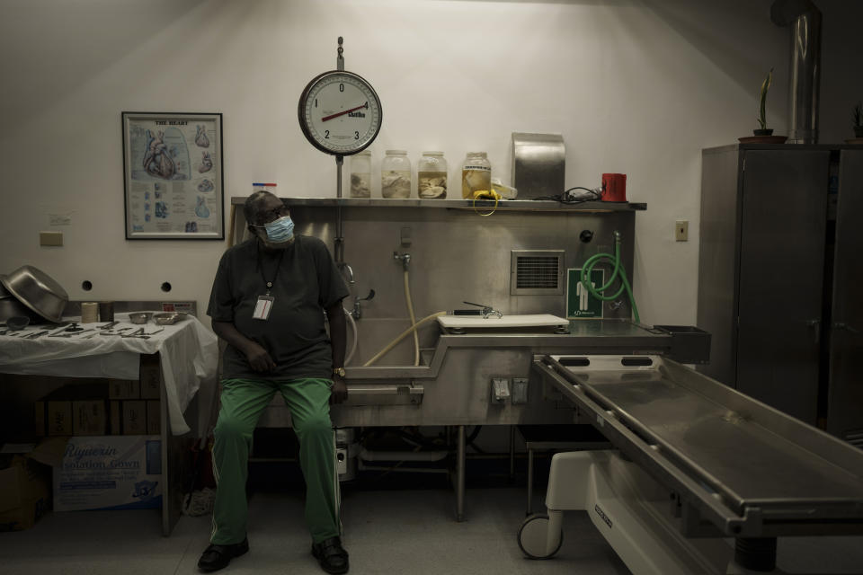 Mortuary technician Thomas Philips sits inside the morgue at the Scarborough hospital on the island of Tobago, Trinidad and Tobago, Tuesday, Jan. 25, 2022. (AP Photo/Felipe Dana)