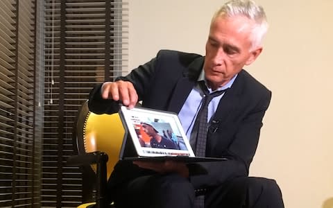 Jorge Ramos shows a video he says his crew shot showing Venezuelan youth picking food scraps out of the back of a garbage truck in Caracas. Mr Ramos claims it was this footage which prompted the team's detention - Credit: STF