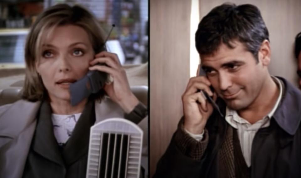 Split-screen of actor Michelle Pfeiffer talking on the phone in a taxi cab. Next to her on the other screen is actor George Clooney also talking on the phone.