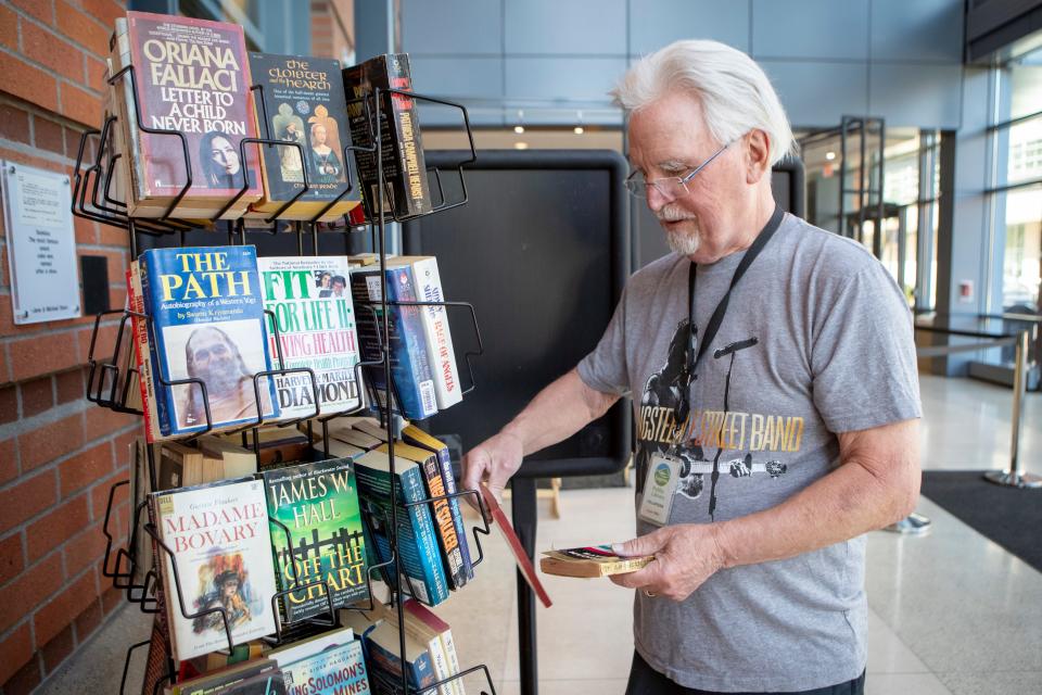 Volunteer Kevin Miller stocks books on the Friends of Eugene Public Library’s “read and return” shelf in the lobby of the Eugene Public Library on Wednesday.