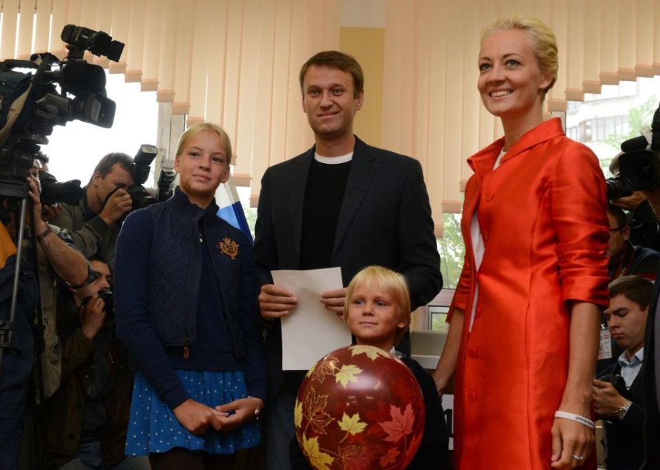 alexei navalny stands with wife yulia navalnaya and their children dasha and zakhar as cameras surround the family on either side, all four smile