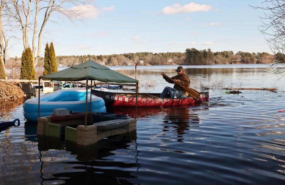 Charlie Reichert helps a neighbor by returning their swimming pool to their front yard as homes were flooded along Bixby Drive, which borders Robbons Pond, in East Bridgewater on Friday, Jan. 27, 2023. 