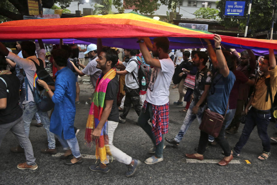 Gay rights activists walk with a rainbow colored flag during a rally to commemorate the twentieth anniversary of the first pride parade in the country, in Kolkata, India, Saturday, June 29, 2019. (AP Photo/Bikas Das)
