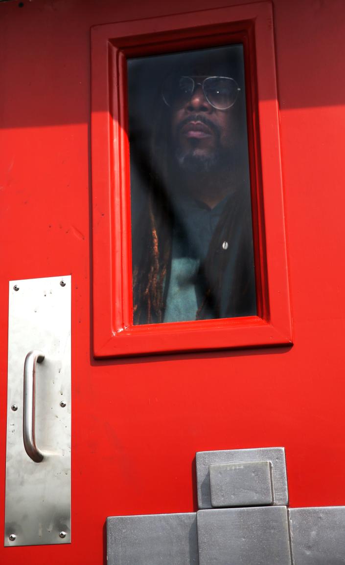 Milwaukee Journal Sentinel reporter James E. Causey peers out a small window from inside a replica of a solitary confinement cell.