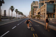 People ride on a car-free road during Yom Kippur, the holiest day in the Jewish year, during a nationwide three-week lockdown to curb the spread of the coronavirus, in Tel Aviv, Israel, Sunday, Sept. 27, 2020. (AP Photo/Oded Balilty)