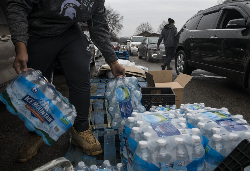 FLINT, MICHIGAN - DECEMBER 20: Workers load bottled water into vehicles waiting in line at a water distribution site at Greater Holy Temple in Flint, Mich., on Thursday, December 20, 2018. (Photo by Brittany Greeson/The Washington Post via Getty Images)