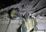 Maarouf, a 12-year-old Syrian boy waits to be rescued from the rubble of a building following a reported air strike on the the rebel-held Qaterji neighbourhood of the northern city of Aleppo