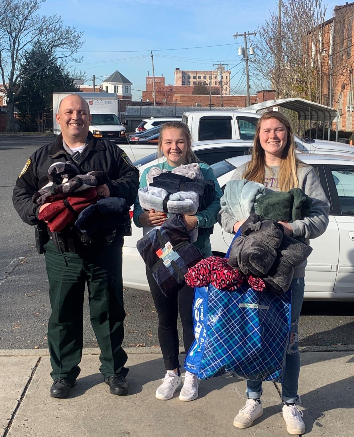 Gaston County Police Officer Jeff Thompson and Bessemer City High School students Riley Royer and Lacey Pettry take blankets they helped collect to the Salvation Army shelter in Gastonia in December 2021.