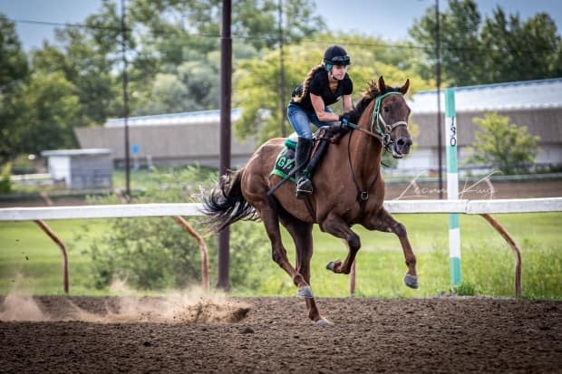 Nicole Hein, an apprentice jockey and an advocate for the Saskatchewan horse-racing industry, can be seen in this supplied photo during a morning gallop at Prairieland Park. She says concern from an elected official about the cancellation of the upoming season is welcome. 