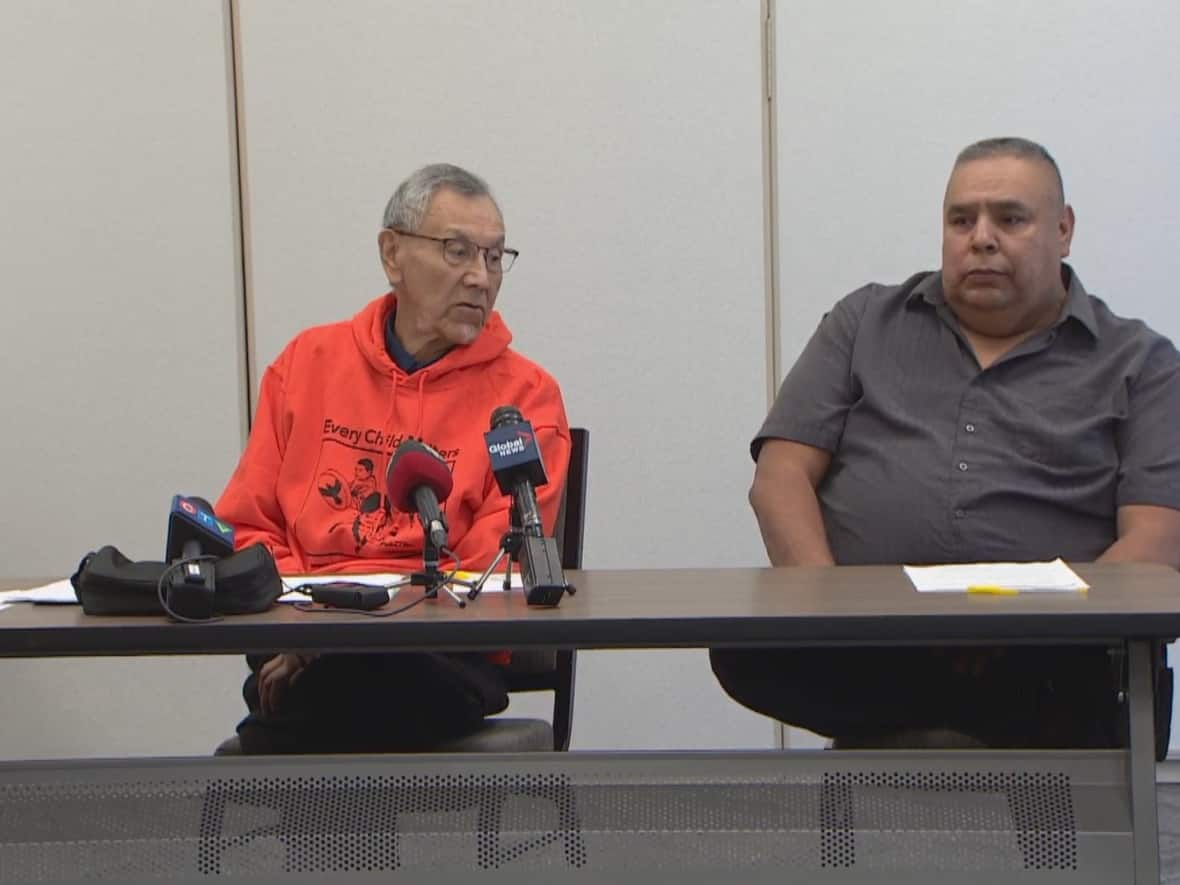 Lead investigator and residential school survivor Eric Large, left, and Saddle Lake council member Jason Whiskeyjack are shown at a news conference on Tuesday to discuss the discovery of information about unmarked burials near the Blue Quills residential school. (Peter Evans/CBC - image credit)