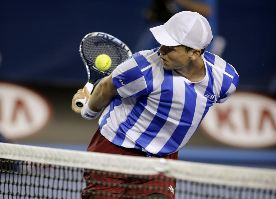 Tomas Berdych of the Czech Republic mis-hits the ball against Stanislas Wawrinka of Switzerland during their semifinal at the Australian Open tennis championship in Melbourne, Australia, Thursday, Jan. 23, 2014.(AP Photo/Rick Rycroft)