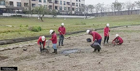 南市工務局派工清理南科蓮潭公園滯洪池底死魚，避免臭味飄散。（記者李嘉祥攝）