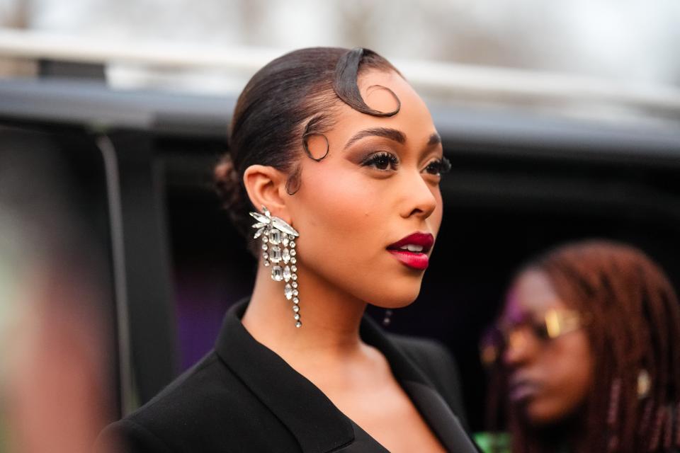 PARIS, FRANCE - JANUARY 24: Jordyn Woods wears bejeweled earrings, red lipstick, a black blazer jacket, outside Zuhair Murad, during the Haute Couture Spring/Summer 2024 as part of  Paris Fashion Week on January 24, 2024 in Paris, France. (Photo by Edward Berthelot/Getty Images)