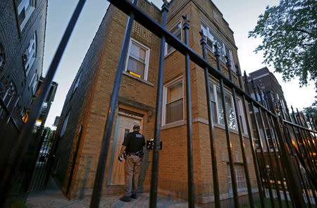 A Cook County Sheriff police officer visits a residence as he tries to serve an outstanding arrest warrant in the Austin neighborhood in Chicago, Illinois, United States, September 9, 2015. REUTERS/Jim Young