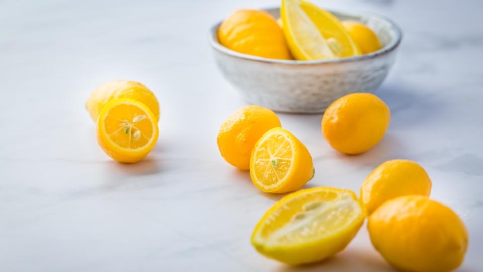 Limequats, a common hybrid fruit, in a bowl and on a table