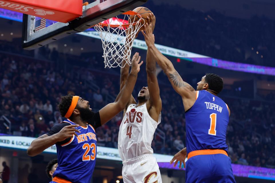 Cleveland Cavaliers forward Evan Mobley (4) shoots against New York Knicks center Mitchell Robinson (23) and forward Obi Toppin (1) during first half of an NBA basketball game Friday, March 31, 2023, in Cleveland. (AP Photo/Ron Schwane)