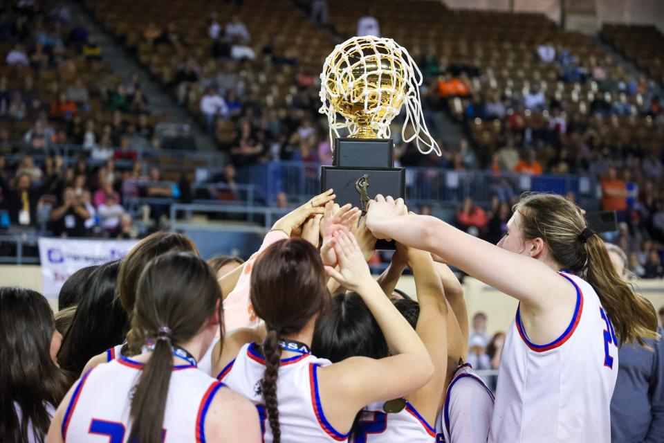 The Hammon Lady Warriors raise their trophy after defeating Lomega Lady Raiders for the Class B girls championship game at the Jim Norick Arena in Oklahoma City on Saturday, March 4, 2023. 