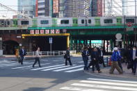 <p>Pedestrians cross the street near Shinbashi Station in Tokyo’s Minato Ward. (Photo: Michael Walsh/Yahoo News) </p>