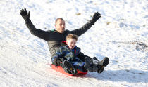 Dave Armitage with son Brodie enjoy sledging in the snow at Tatton Park, Knutsford. (PA)