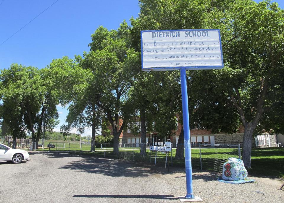 FILE - In this May 26, 2016, file photo, an empty school reader board stands in front of the only school building in Dietrich, Idaho. The small community is struggling with the national attention brought by reports that a disabled black football player was raped by his white high school teammates. The allegations of racist taunts and physical abuse suffered by the teen were revealed this month when the family filed a $10 million lawsuit against the Dietrich School District. (AP Photo/Kimberlee Kruesi, File)