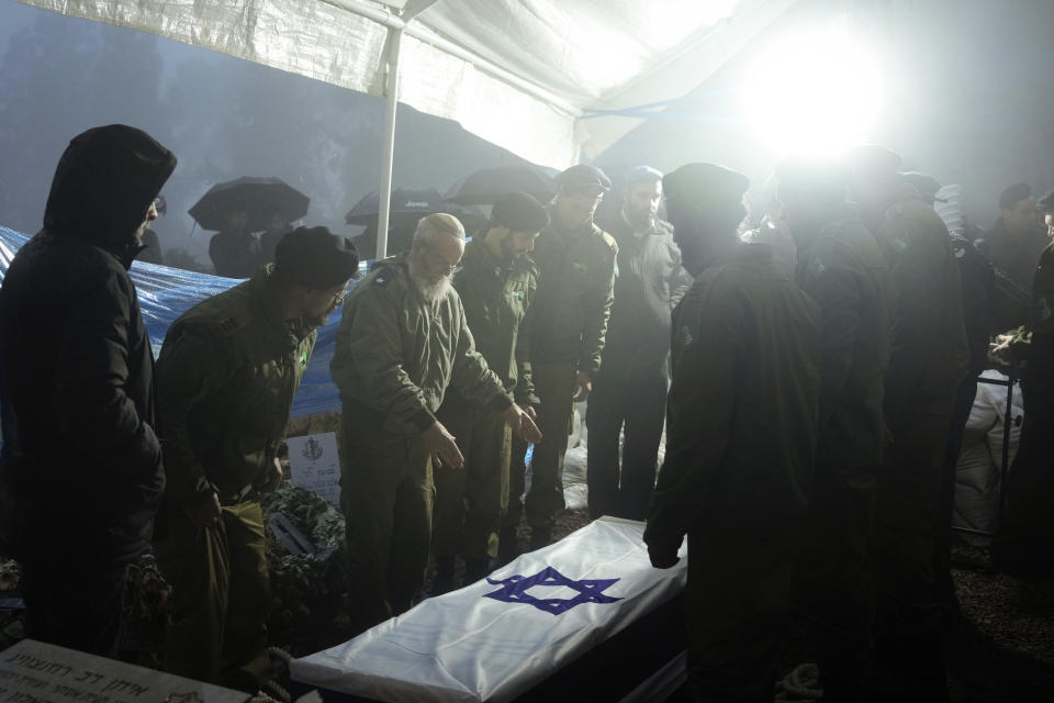 Israeli soldiers lower the flag-draped casket of reservist Ariel Mordechay Wollfstal during his funeral at a cemetery in the West Bank settlement of Kfar Etzion, Tuesday, Jan. 23, 2024. Wollfstal, 28, was killed during Israel's ground operation in the Gaza Strip, where the Israeli army has been battling Palestinian militants in the war ignited by Hamas' Oct. 7 attack into Israel. (AP Photo/Maya Alleruzzo)