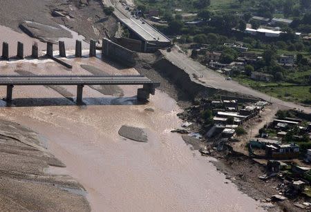 An aerial view taken from an Air Force's helicopter shows the remains of a bridge after it was swept away by floodwaters from the river Tawi on the outskirts of Jammu September 9, 2014. REUTERS/Mukesh Gupta