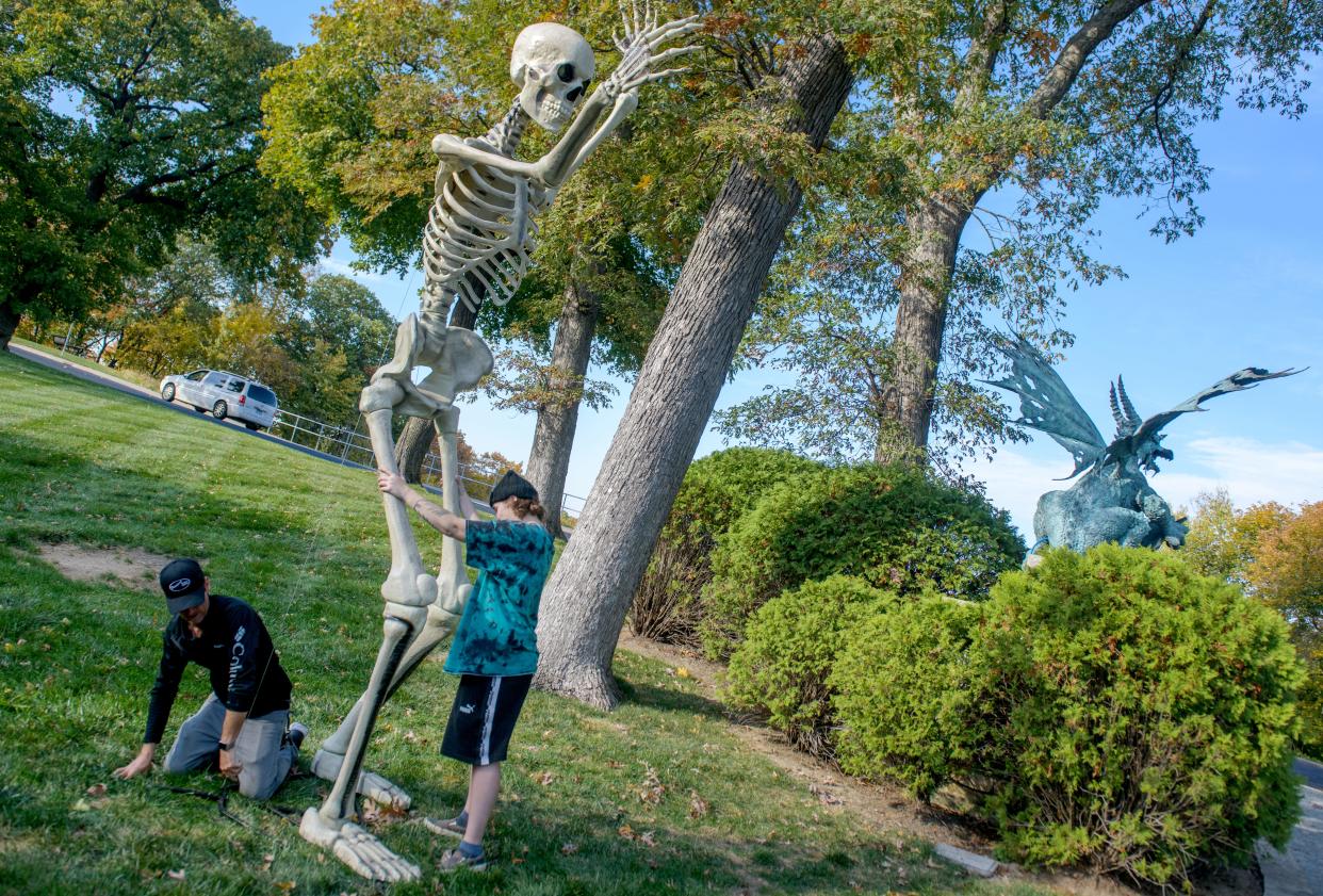 Ryan Wyss, left, and his daughter Payton Wyss raised a giant skeleton at the entrance to Soderstrom Castle in preparation for the annual Halloween display Monday, Oct. 23, 2023 on Grandview Drive in Peoria.
