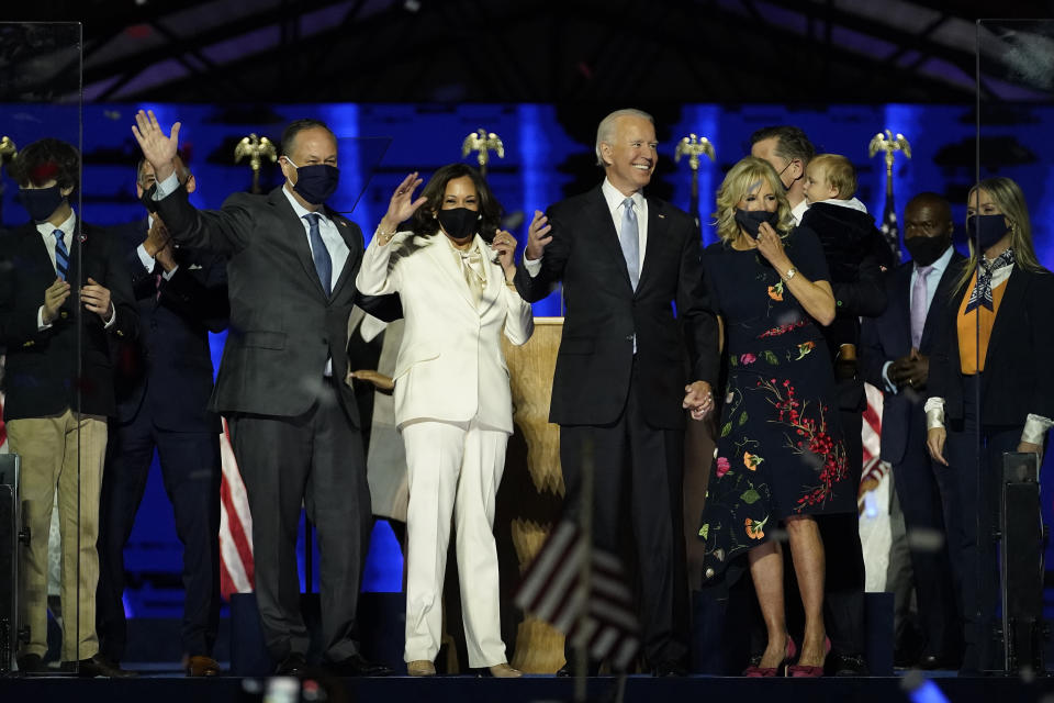 From left, Doug Emhoff, husband of Vice President-elect Kamala Harris, Harris, President-elect Joe Biden and his wife Jill Biden on stage together, Saturday, Nov. 7, 2020, in Wilmington, Del.(AP Photo/Andrew Harnik, Pool)
