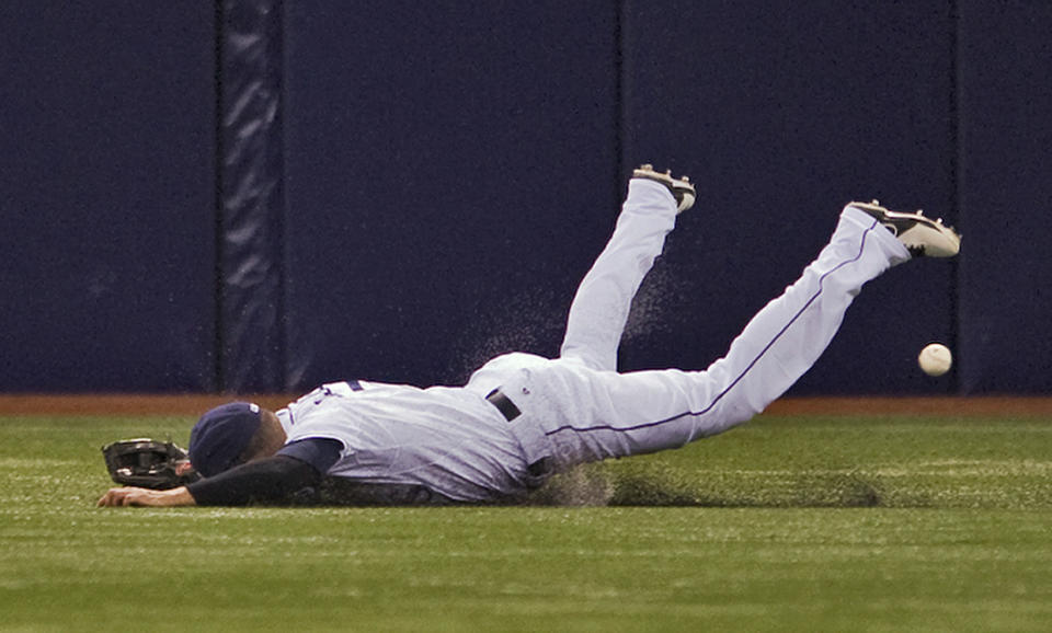 Tampa Bay Rays center fielder David DeJesus hits the turf after coming up short on a three-run double hit by New York Yankees' Scott Sizemore during the second inning of a baseball game Friday, April 18, 2014, in St. Petersburg, Fla. (AP Photo/Steve Nesius)