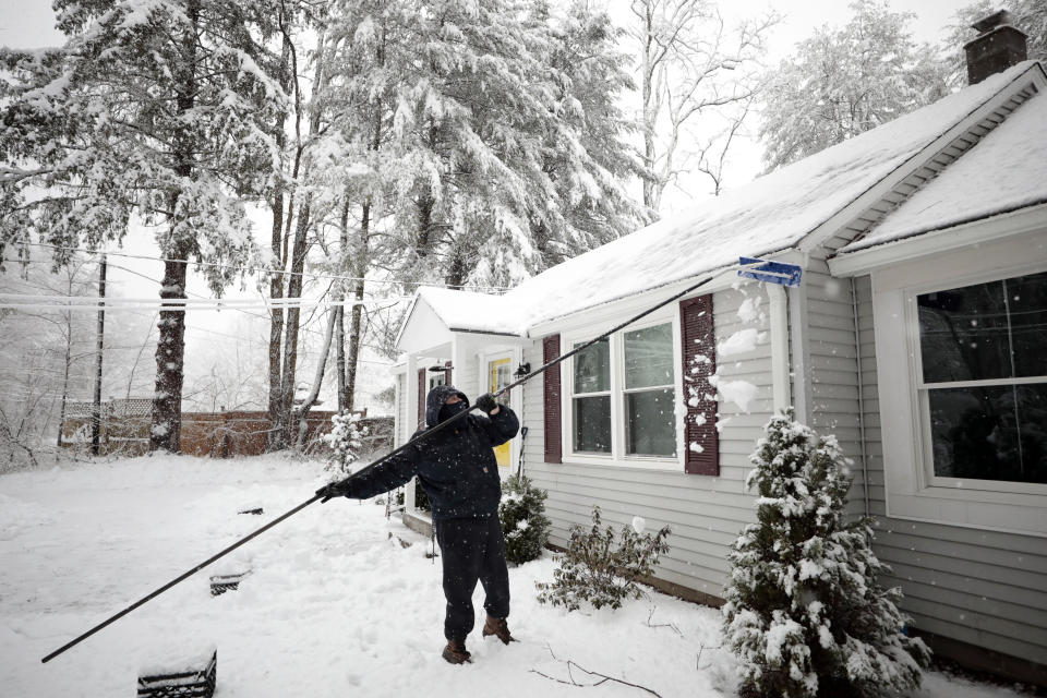 Kevin Bousquet scrapes off heavy snow to relieve the weight on his roof on Berkshire School Road in Sheffield during the nor'easter that hit the Berkshires early Tuesday morning. Tuesday, March 14, 2023. (Stephanie Zollshan/The Berkshire Eagle via AP)