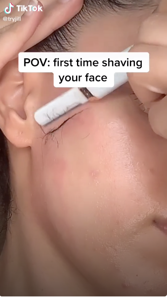 An up-close shot of a person shaving their cheek with the text, "POV: first time shaving your face"