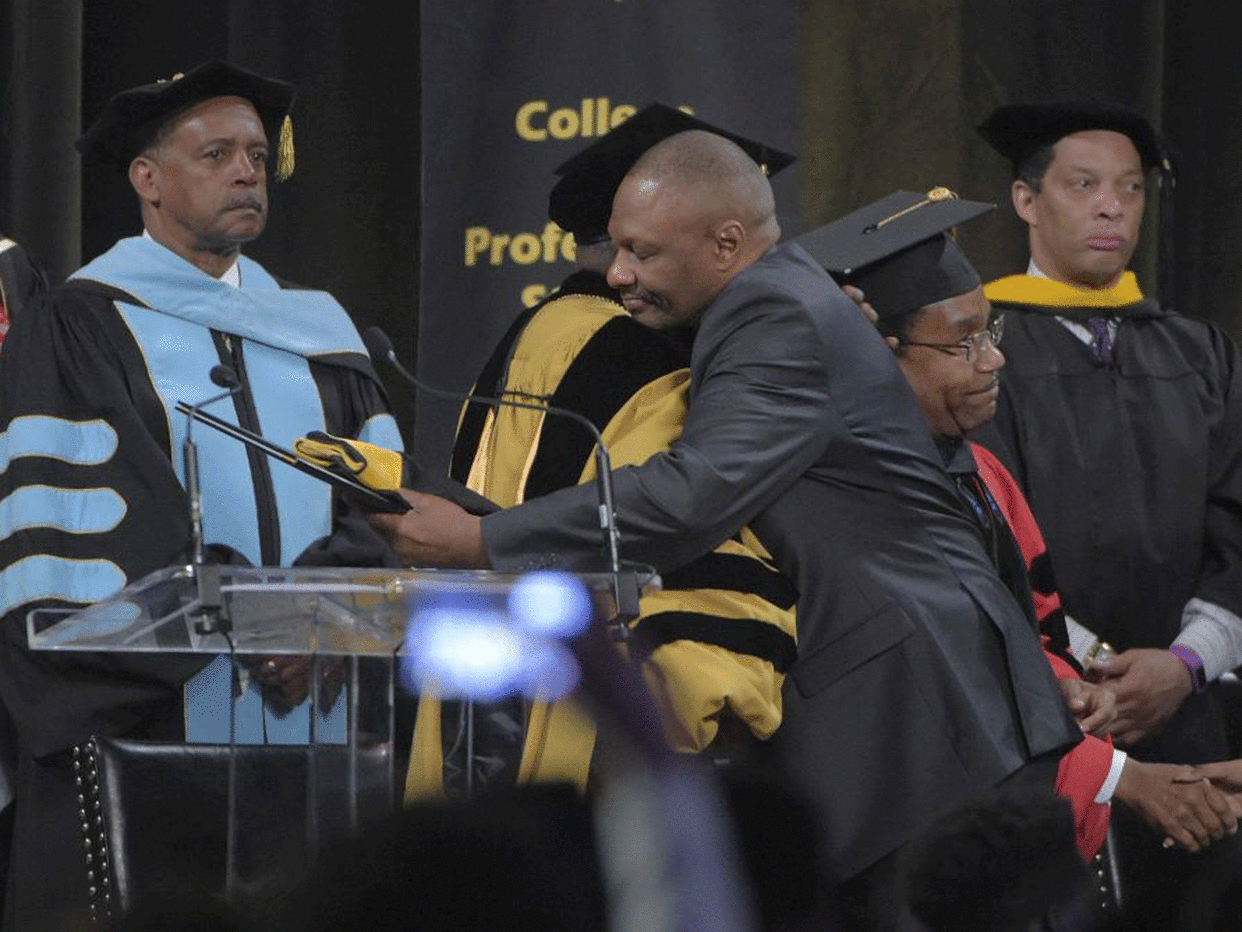 Bowie State University President Dr Mickey L. Burnim hugs Richard Collins Jr., father of Richard Collins III, at the school's graduation ceremony: Karl Merton Ferron/The Baltimore Sun via AP