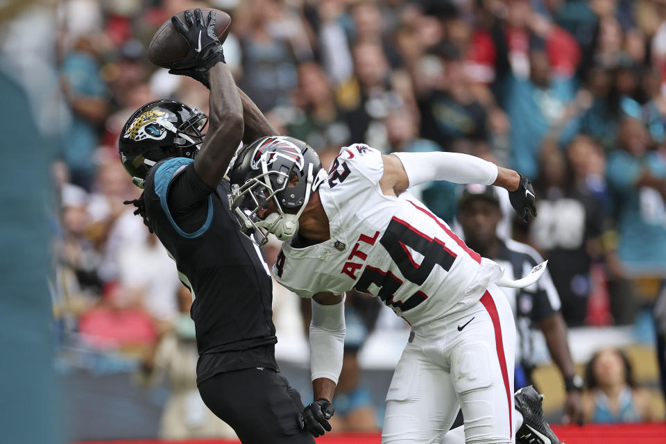 Jacksonville Jaguars wide receiver Calvin Ridley (0) catches the ball ahead of Atlanta Falcons cornerback A.J. Terrell (24) to score a touchdown during the first quarter of an NFL football game between the Atlanta Falcons and the Jacksonville Jaguars at Wembley stadium in London, Sunday, Oct. 1, 2023. (AP Photo/Ian Walton)