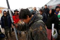 <p>Oscar High Elk, 26, of the Cheyenne River Sioux Tribe, prays as he and other members of the tribe prepare to evacuate from the main opposition camp against the Dakota Access oil pipeline near Cannon Ball, North Dakota, U.S., February 22, 2017. (Terray Sylvester/Reuters) </p>